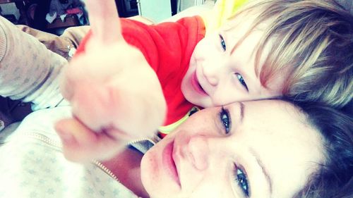 Close-up portrait of happy mother and daughter at home