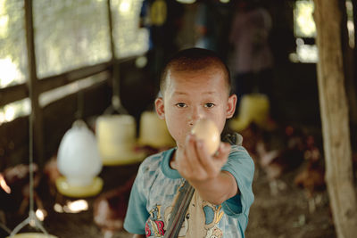 Portrait of cute boy holding egg