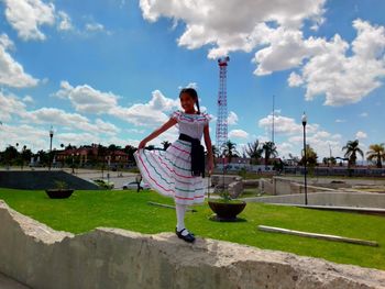 Woman standing on street against sky