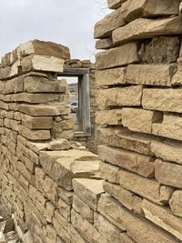 Low angle view of stone wall against building