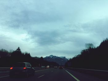 Country road against cloudy sky