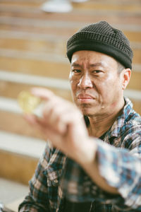 Portrait of beggar holding coin