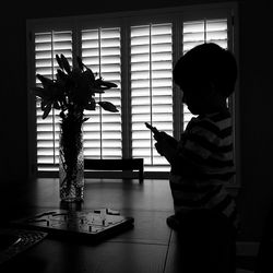 Rear view of people looking through window