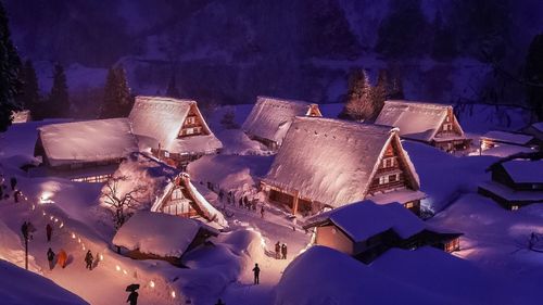 High angle view of snow covered houses at night