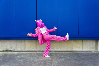 Side view of girl against pink wall