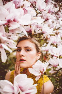 Portrait of young woman amidst pink flowers