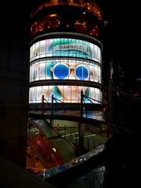 Reflection of illuminated building on glass window at night