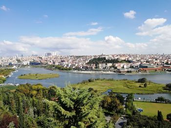 Scenic view of river by town against sky