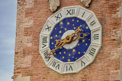 Low angle view of clock on building wall