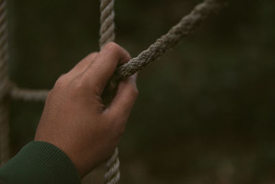 Close-up of hand holding rope