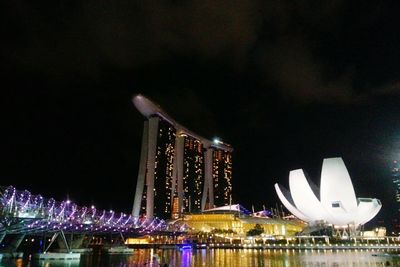 Illuminated bridge over river at night