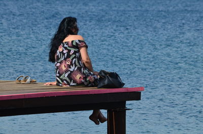 Side view of woman sitting on boat in sea