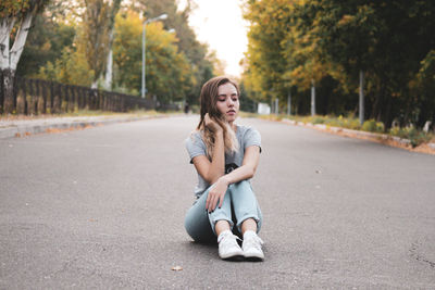 Portrait of woman sitting on road