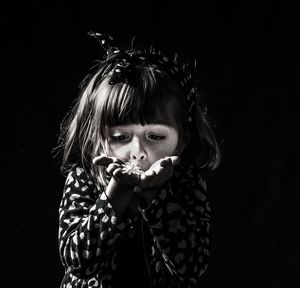 Portrait of cute girl holding black background