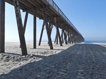 View of pier on beach against clear sky