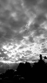 Silhouette of trees against cloudy sky