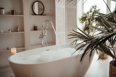 Luxury interior of big bathroom at modern african style with oval bathtub in natural lighting