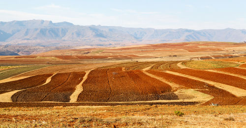 Scenic view of desert against cloudy sky