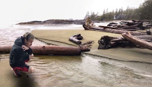 Man with horse on beach by sea