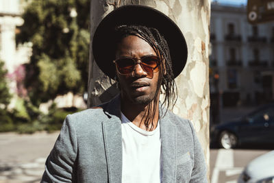 Portrait of young man in hat at city