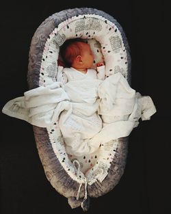 Close-up of a boy sleeping against black background