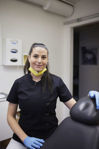 Female dentist standing in office