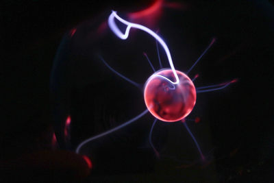 Close-up of illuminated lighting equipment against black background