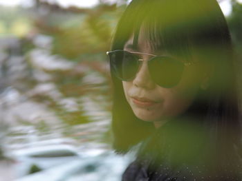 Close-up portrait of young woman wearing sunglasses