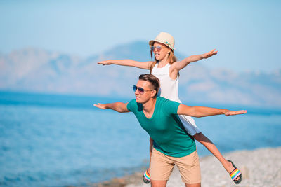 Full length of young couple standing on beach