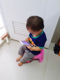 High angle view of boy sitting on floor at home