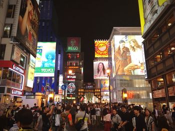 People on illuminated street at night in city