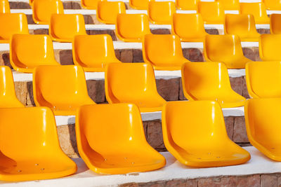 Stone steps with yellow plastic seats. empty stools without people.