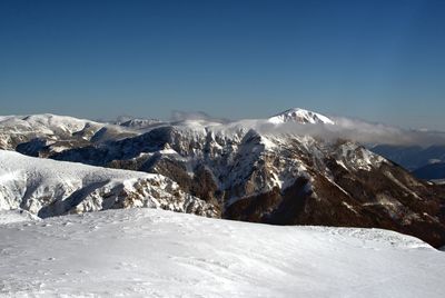 Scenic view of snowcapped mountains against clear sky