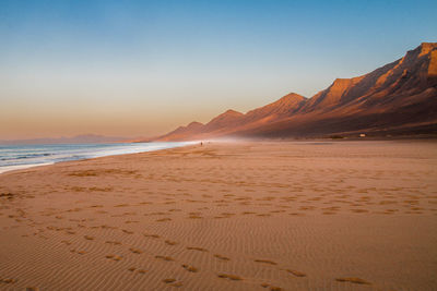 Scenic view of beach against sky during sunset