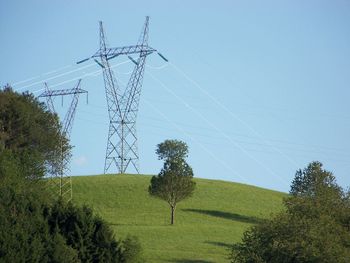 Electricity pylon on field against sky