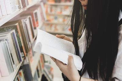 Midsection of woman reading book