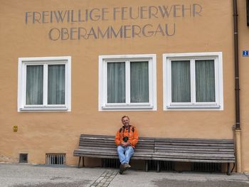 Full length portrait of woman standing against building