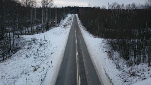 High angle view of road amidst snow covered field