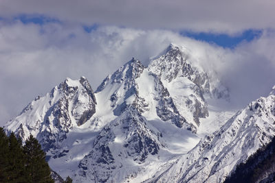 Low angle view of snowcapped mountains against sky