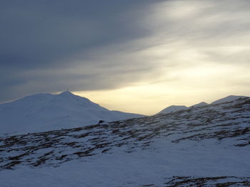 Scenic view of snowcapped mountains against sky during sunset