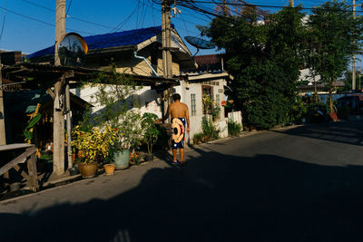 Street by buildings in city against sky