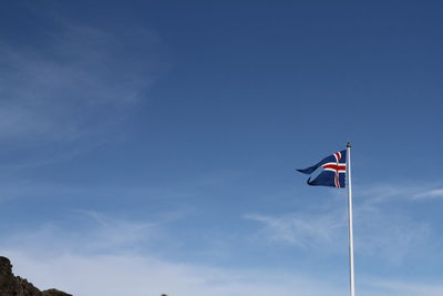 Low angle view of flag flags against sky