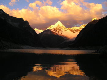 Scenic view of lake by mountains against sky