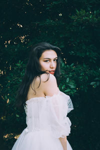 Portrait of woman standing against plants