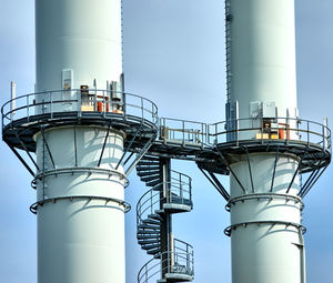 Abstract image of two chimneys with platforms connected by a spiral staircase