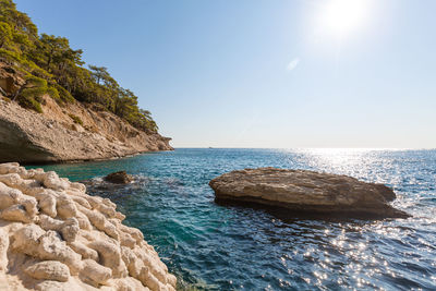 Large white stones in azure water against the background of rocks