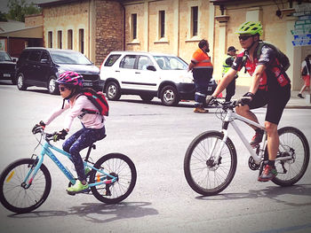 People riding bicycle on street in city