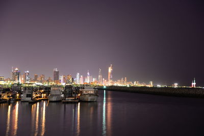 Illuminated cityscape against sky at night