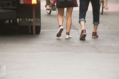 Low section of woman walking on road