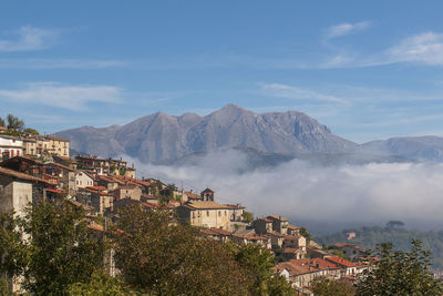 Town by mountain against sky